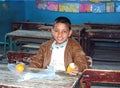 Young boy having his meal at school in class