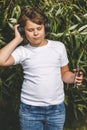 Young boy in headphones with smartphone listens to music in the park Royalty Free Stock Photo