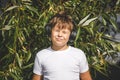 Young boy in headphones with smartphone listens to music in the park Royalty Free Stock Photo