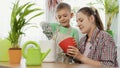 Young boy helping his mother pouring soil in flowers pots. Concept of gardening, home planting and family working Royalty Free Stock Photo