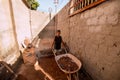 A young boy helping to cleaning up dirt and rocks in front of his house