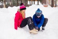 Young boy helps to the girl ties bootlaces up skates Royalty Free Stock Photo