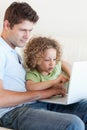 Young boy and his father using a laptop Royalty Free Stock Photo