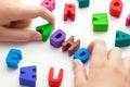 A young boy holding the abbreviation ADHD that is made out of polymer clay letters