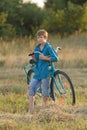 Young boy holding bicycle in farm field Royalty Free Stock Photo