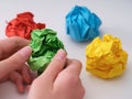 A young boy holding a green colorful crumpled paper ball above other paper balls Royalty Free Stock Photo