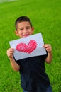 Young boy holding heart drawing