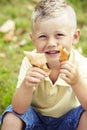 Young boy holding leaves outdoors