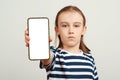 Young boy holding mobile phone with white blank screen in hand. Gadget with empty free space for mock up Royalty Free Stock Photo