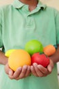 Young boy holding plastic fruit and vegetables