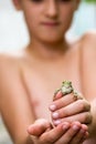 Young boy holding a tiny green frog in his hands Royalty Free Stock Photo
