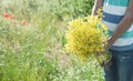 Young boy holding yellow flowers in the field Royalty Free Stock Photo