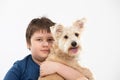 Young boy holds his dog in his arms. Subject isolated from the background.