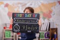 a young boy holds up a chalk board sign that says first day of kindergarten Royalty Free Stock Photo