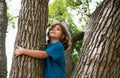 Young boy hugging a tree branch. Little boy kid on a tree branch. Child climbs a tree. Royalty Free Stock Photo