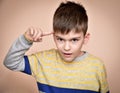 Young boy with the index finger on his head Royalty Free Stock Photo