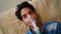 Young boy infected with Covid 19 disease. Patient inhaling oxygen wearing mask with liquid Oxygen flow