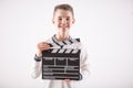 Young boy on an isolated white background holds an open movie clapper board Royalty Free Stock Photo