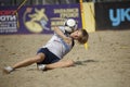 Young boy juggling with the soccer ball on the beach stadium