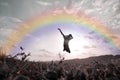 Young boy jumping high in air against sunset with rainbow Royalty Free Stock Photo