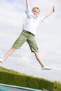 Young boy jumping on trampoline smiling Royalty Free Stock Photo