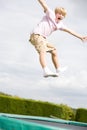 Young boy jumping on trampoline smiling Royalty Free Stock Photo