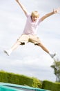 Young boy jumping on trampoline smiling Royalty Free Stock Photo