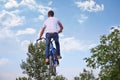 Young boy jumps with mountain bike without helmet