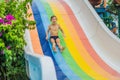 Young boy or kid has fun splashing into pool after going down water slide during summer Royalty Free Stock Photo