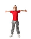 Boy kid in red t-shirt and grey pants spread hands up happy smiling screaming laughing isolated on white Royalty Free Stock Photo