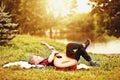 Young boy kid teen child lies in the meadow and playing guitar in a camp or summer picnic near by river or pond Royalty Free Stock Photo