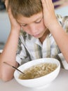 Young boy in kitchen eating soup Royalty Free Stock Photo