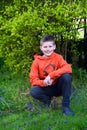 Boy Kneels in Grass with Purple flowers