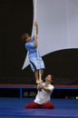 A young boy learns to climb a rope in n acrobat school