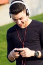 Young boy listening to music with smartphone in the street Royalty Free Stock Photo