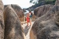 A young boy and long-haired girl brunette kissing among the large stones on the beach. Royalty Free Stock Photo