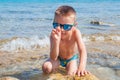 Young boy looking for seashells at the beach