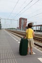 Young boy with luggage waiting for train