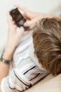 Young boy lying on the floor with his mobile Royalty Free Stock Photo