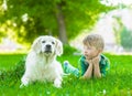 Young boy lying with golden retriever dog on green grass Royalty Free Stock Photo