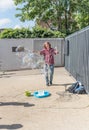 Young boy makes huge soap bubbles on the street