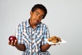 Little boy making decisions of eating healthy verses unhealthy. Royalty Free Stock Photo