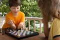 Young boy making a move, Child playing chess summer outdors