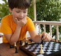 Young boy making a move, Child playing chess summer outdors