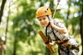 A young boy in a mountain belay and a flip flop goes through an obstacle course. Active, sporty activity in the summer for a child
