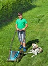 Young boy mowing the lawn accompanied by his labrador doggie Royalty Free Stock Photo