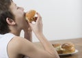 Young boy munching on a cream bun Royalty Free Stock Photo