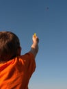 Young Boy in orange shirt flying a kite