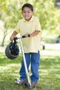 Young boy outdoors on scooter smiling Royalty Free Stock Photo