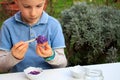 A young boy painting Easter eggs outdoor in France. Easter children creative activity Royalty Free Stock Photo
